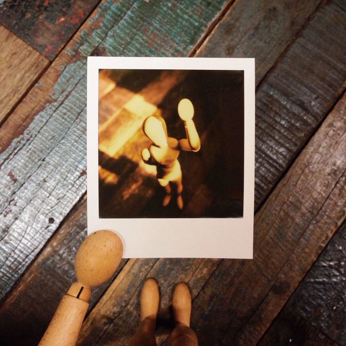 Close-up of instant photo picture of wooden human representation