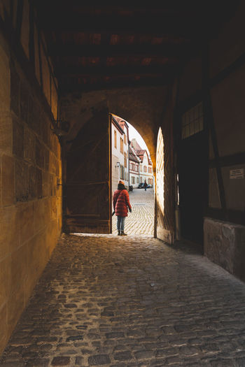 Rear view of girl standing in alley