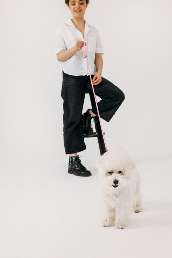 Portrait of man with dog against white background