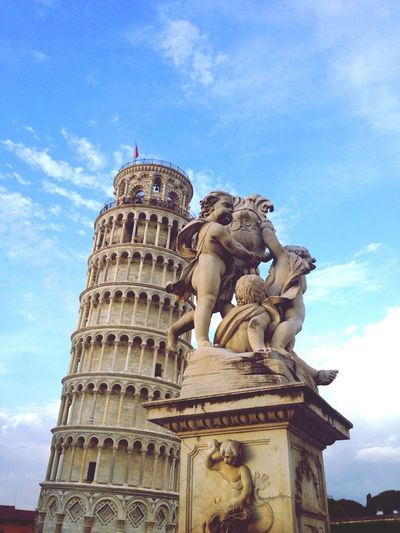 Leaning tower of pisa and fontana dei putti against sky
