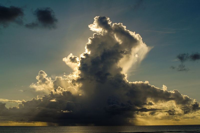 Sunlight streaming through clouds over sea