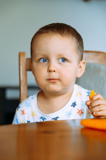 Portrait of cute boy sitting on table