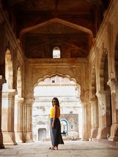 Side view of woman standing in historic building
