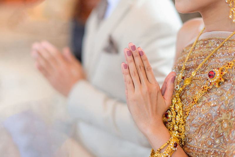 Midsection of woman holding hands against blurred background