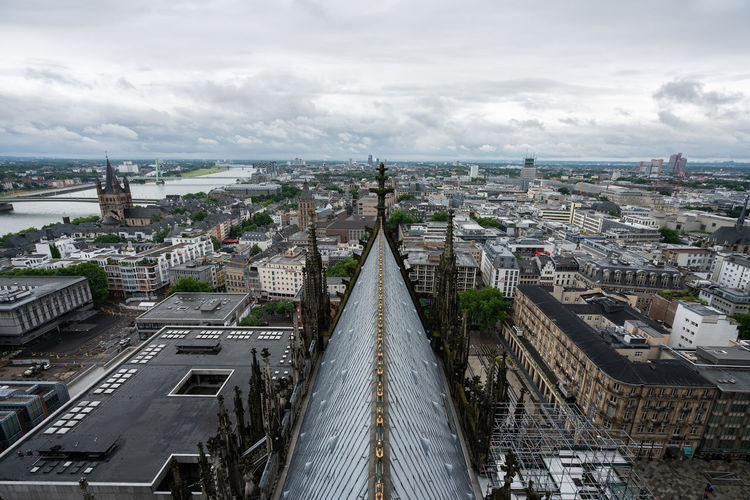 High angle view of city buildings against cloudy sky