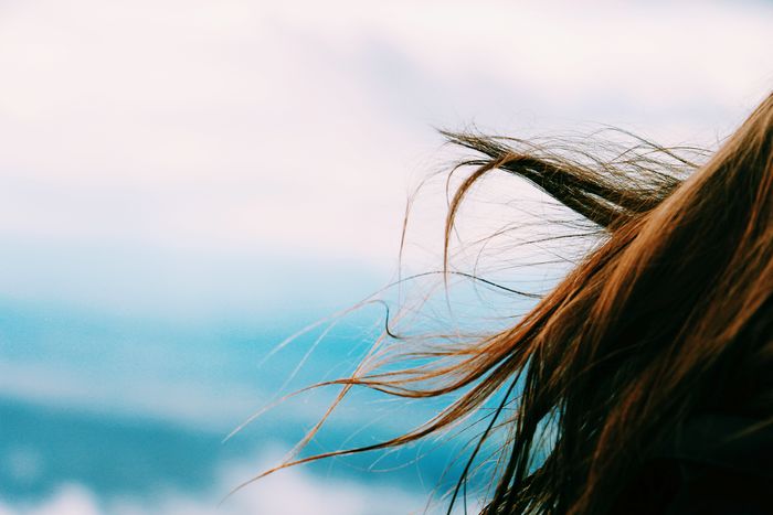 Close-up of the hair of a young woman against sky