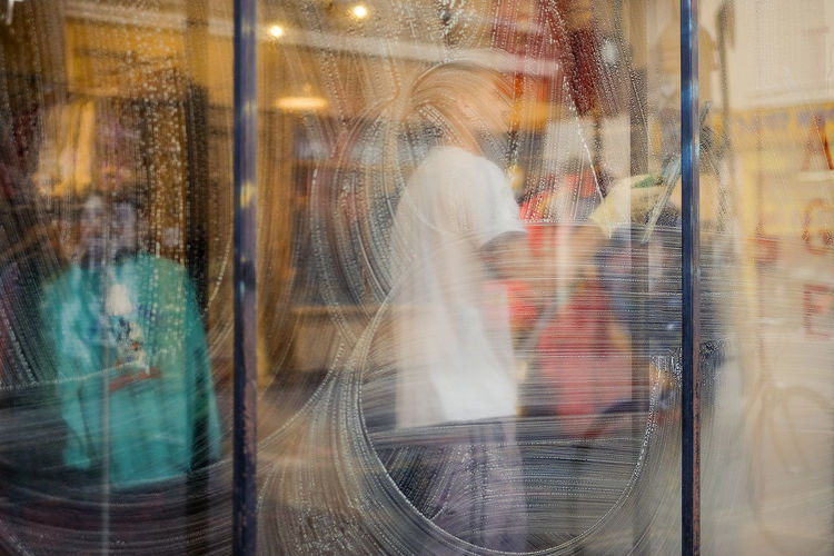 Man cleaning window in clothing store