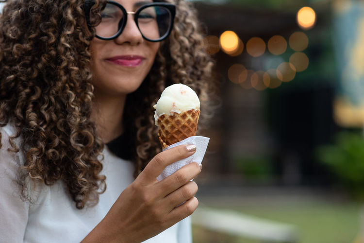 Portrait of woman holding ice cream cone outdoors