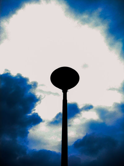 Low angle view of silhouette cross against sky