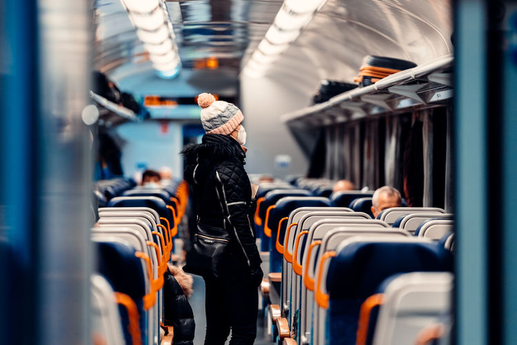 Woman wearing knit hat standing in train