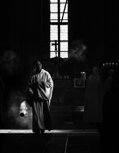 Priest with smoke walking in church