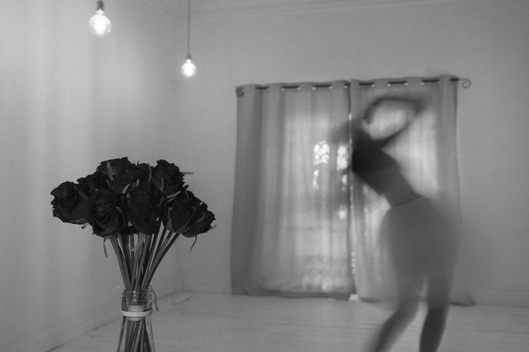 Blurred motion of man in vase against wall at home