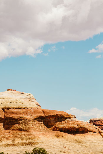 Layers of red sandstone formation under sunny skies in utah desert