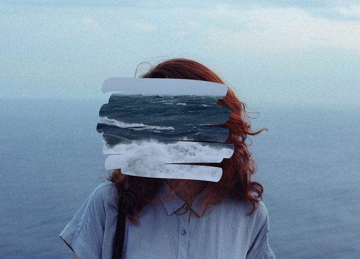 Woman's face obscured by sea