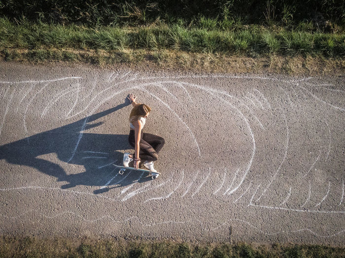 High angle view of woman skateboarding on road
