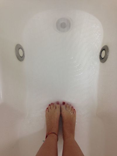 Close-up low section of woman in bathtub