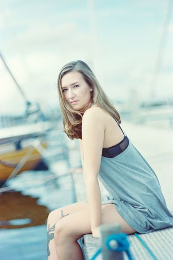 Portrait of young woman sitting on pier