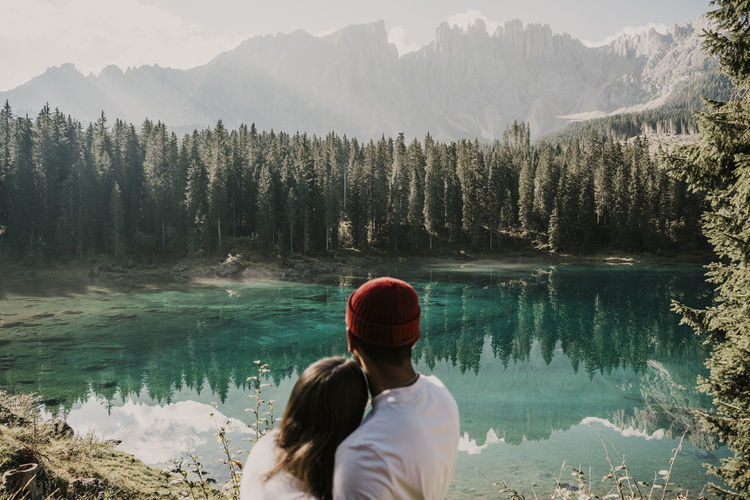 Couple looking at carezza lake in south tyrol, italy