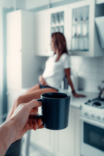 Woman holding coffee cup at home