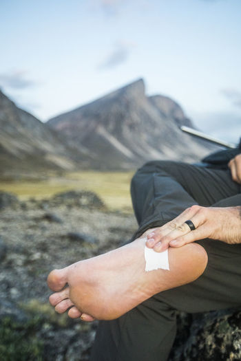 Hiker tapes foot where blister was forming on foot.