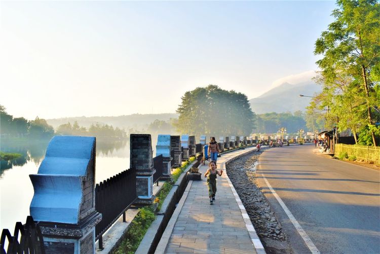 People walking on road in city against clear sky