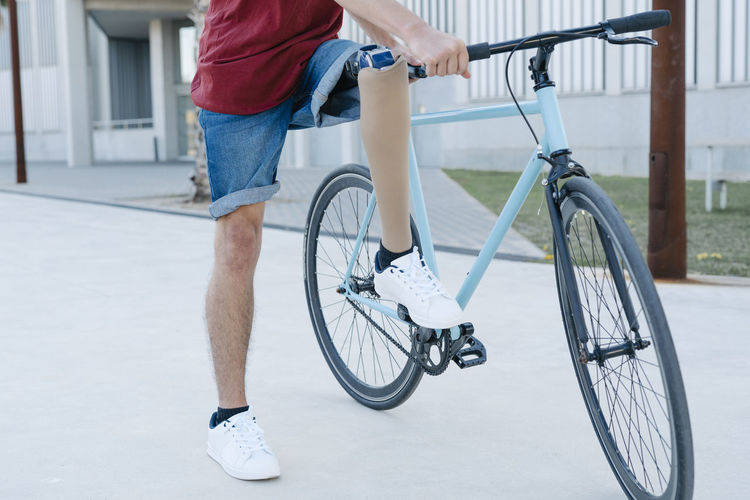 Disabled man riding bicycle on street
