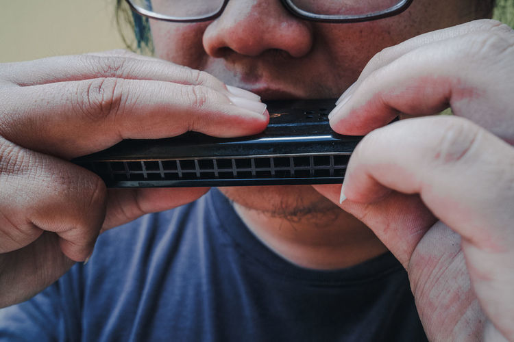 Close-up of man playing harmonica