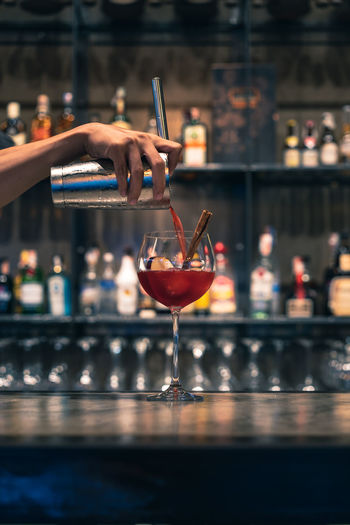 Cropped image of bartender making cocktail at counter