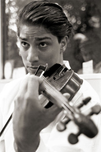 Close-up of man playing violin while standing outdoors
