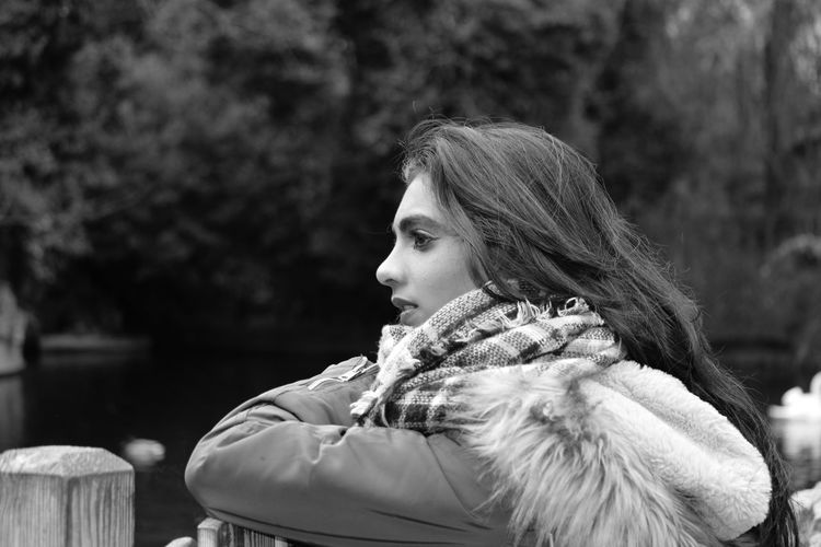 Side view of woman wearing warm clothing looking away in park