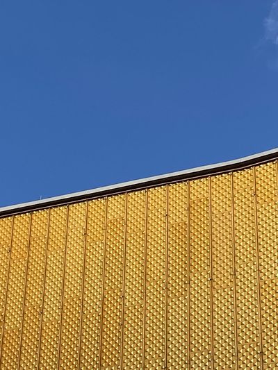 Low angle view of modern building against clear blue sky