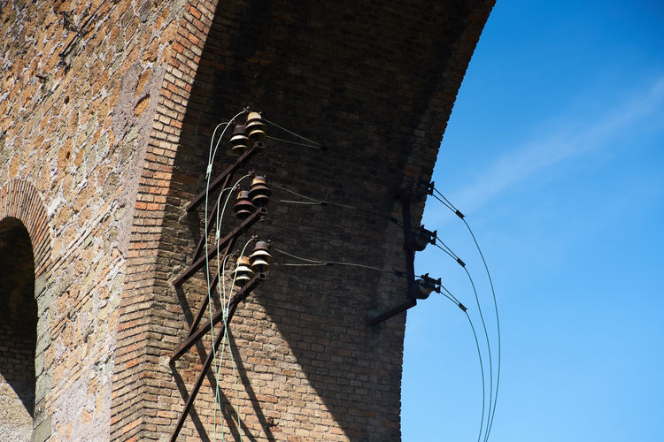 Electricity cables from a brick arch
