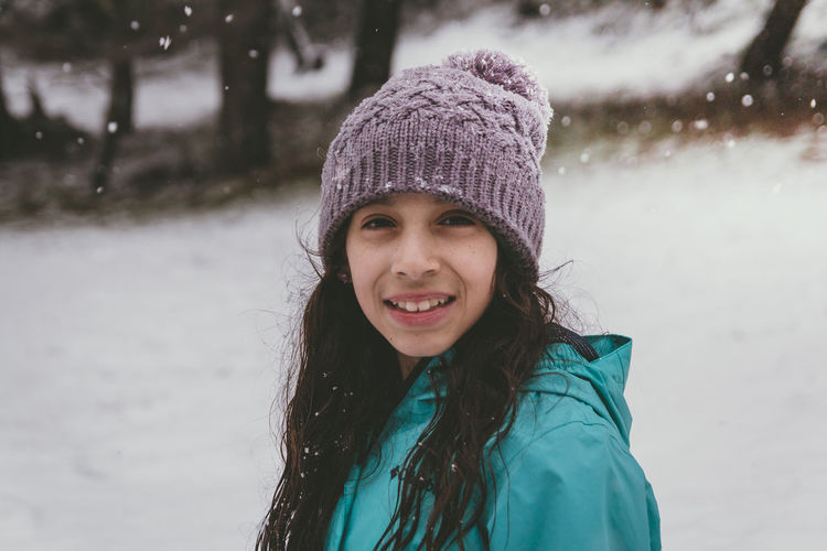 Portrait of smiling girl standing in snow