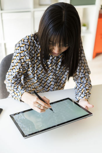 Female design professional using graphic tablet at desk