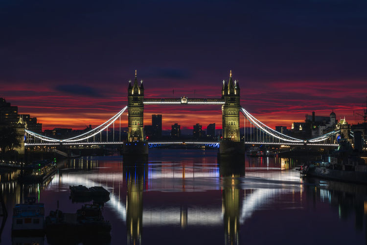Tower bridge illuminated and reflected at dawn