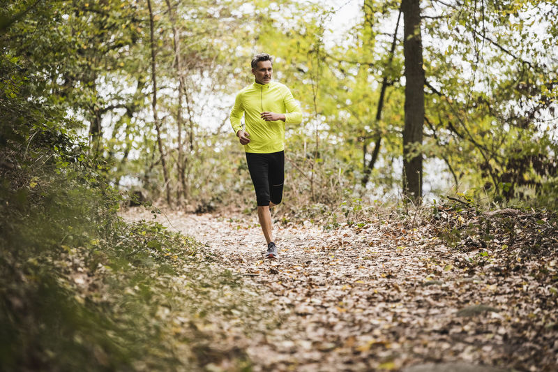 Active mature man running in forest