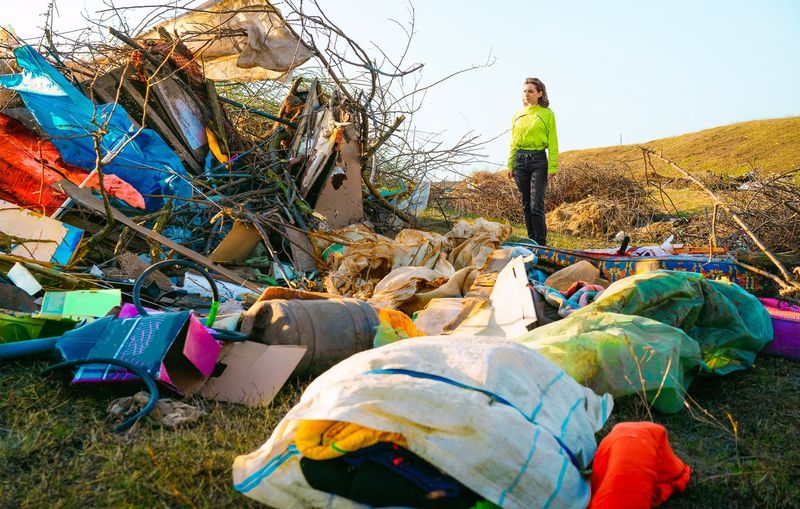 Woman looking at enviromental disaster. illegal garbage dump