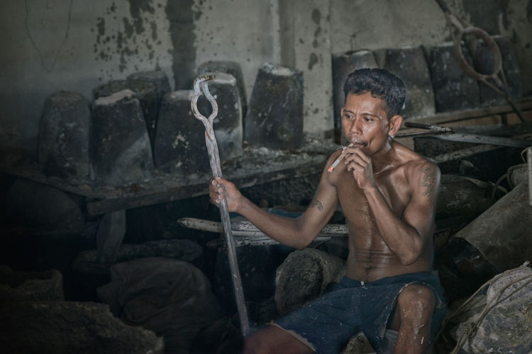 Full length of man sitting on rock