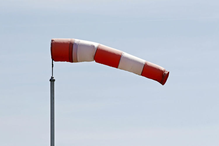 Low angle view of striped windsock against sky