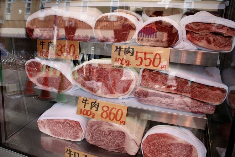 Wagyu beef at store for sale seen through glass window with reflection