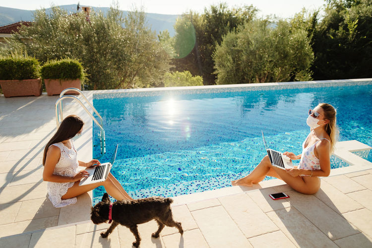 Side view of woman with dog on swimming pool