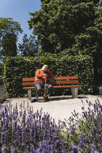 Senior man sitting on park bench, waiting