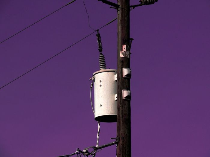 Low angle view of distribution transformer on power line