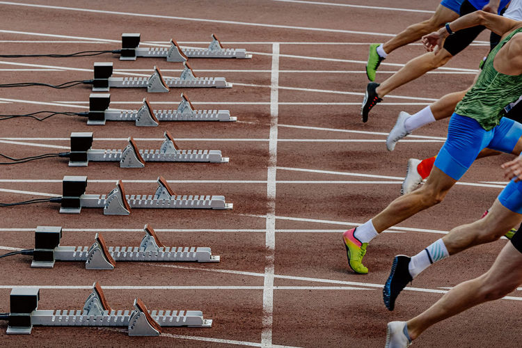 Male athletes starting running in sprinting race