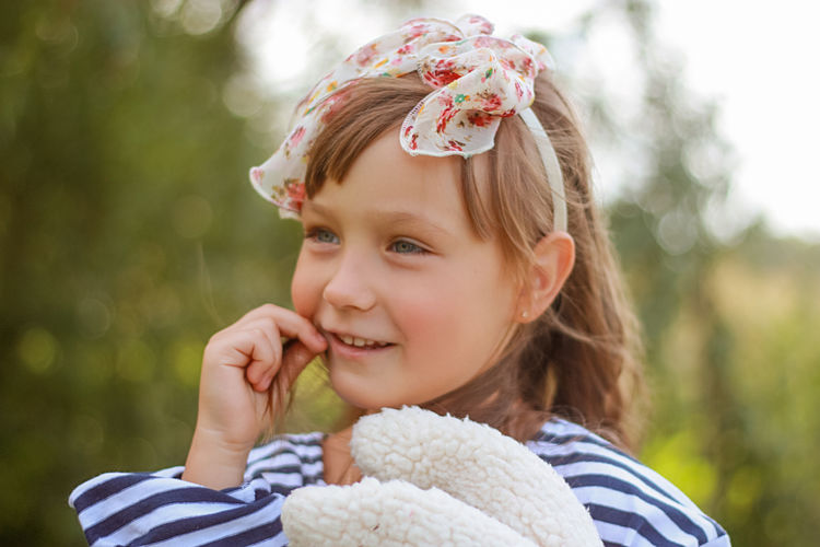 Close-up of girl blowing bubbles while standing outdoors