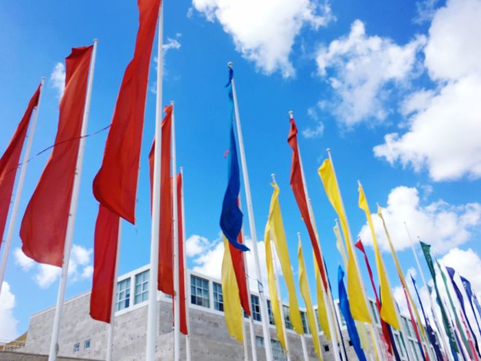 Low angle view of flags hanging against sky