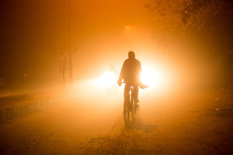 Man riding bicycle at sunset