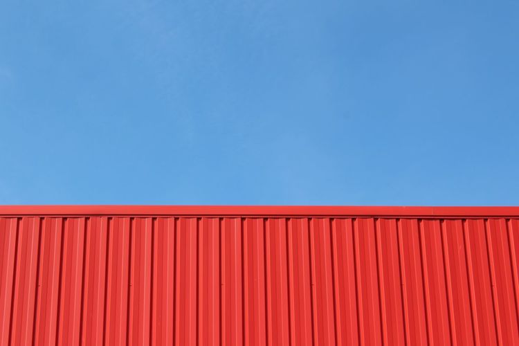Red building structure against blue sky