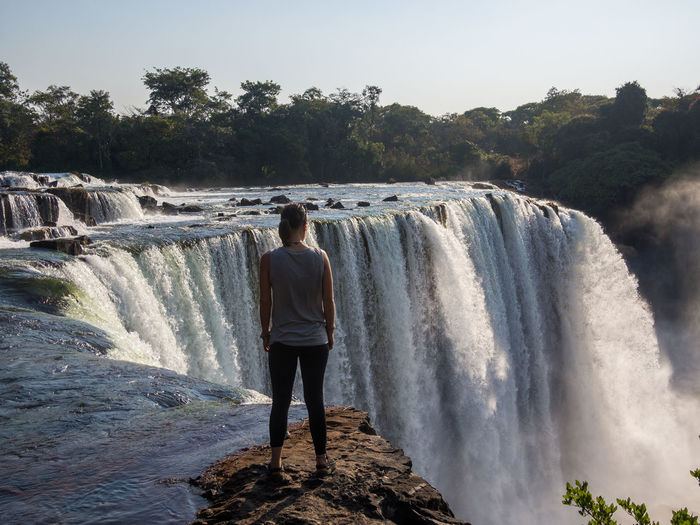Woman standing against lumangwe waterfall, zambia