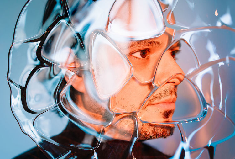 Close-up portrait of man behind glass